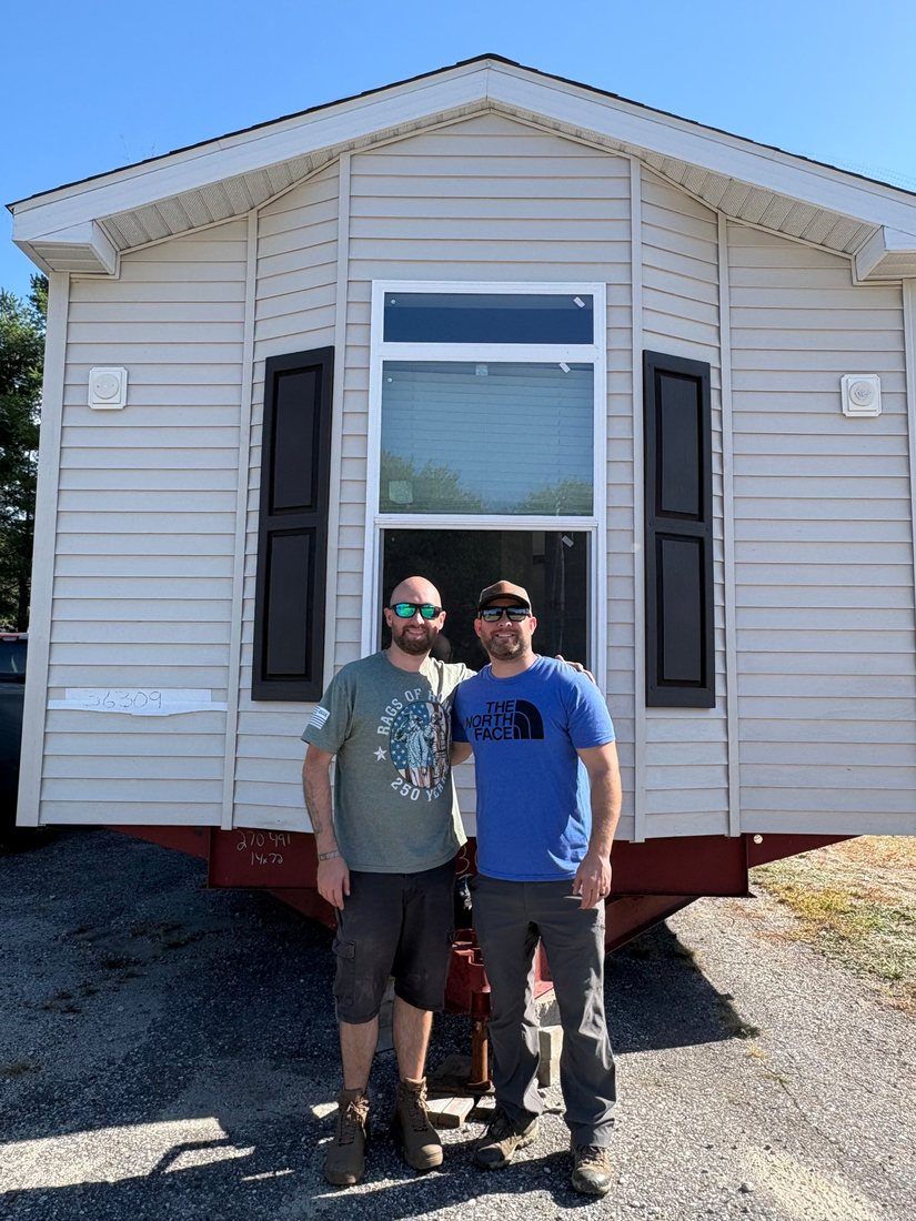 Bryan and Steve Kenney standing in front of a new home on the Baxter Homes lot